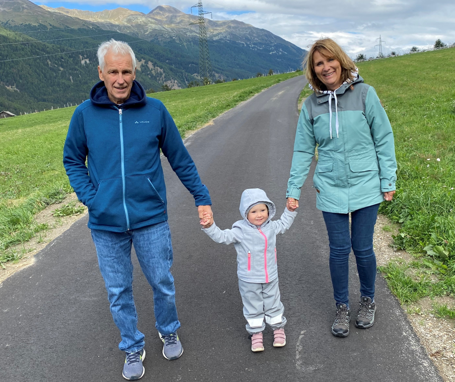 ein Mann und eine Frauen halten ein Kleinkind an der Hand