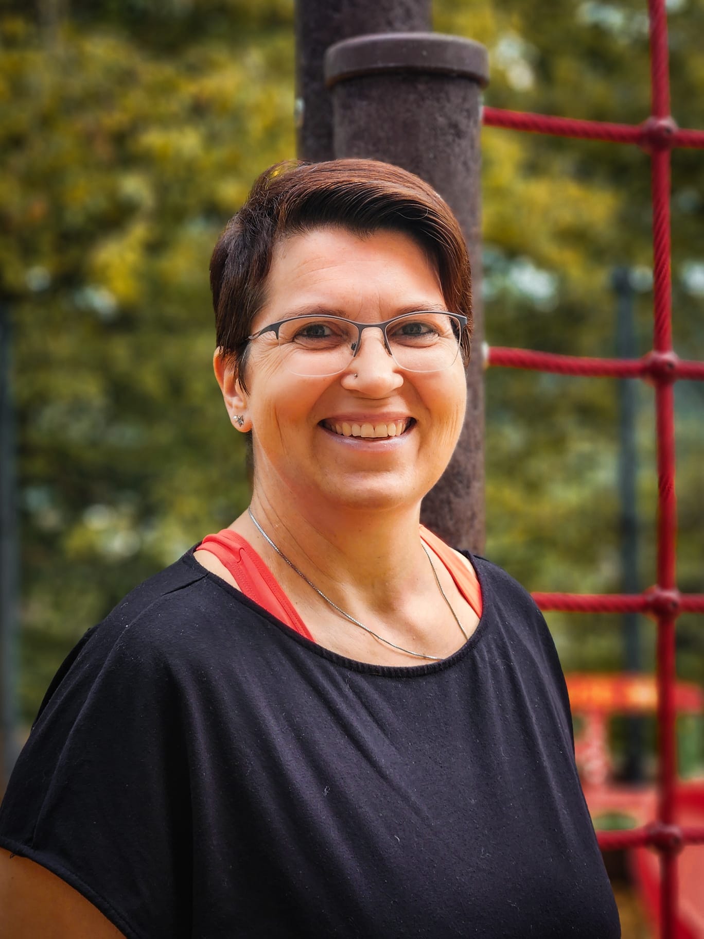 Frau mit kurzen braunen Haaren lächelt in die Kamera