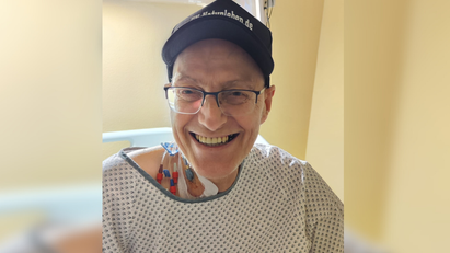 Ein Mann mit Mütze und Patientenhemd
