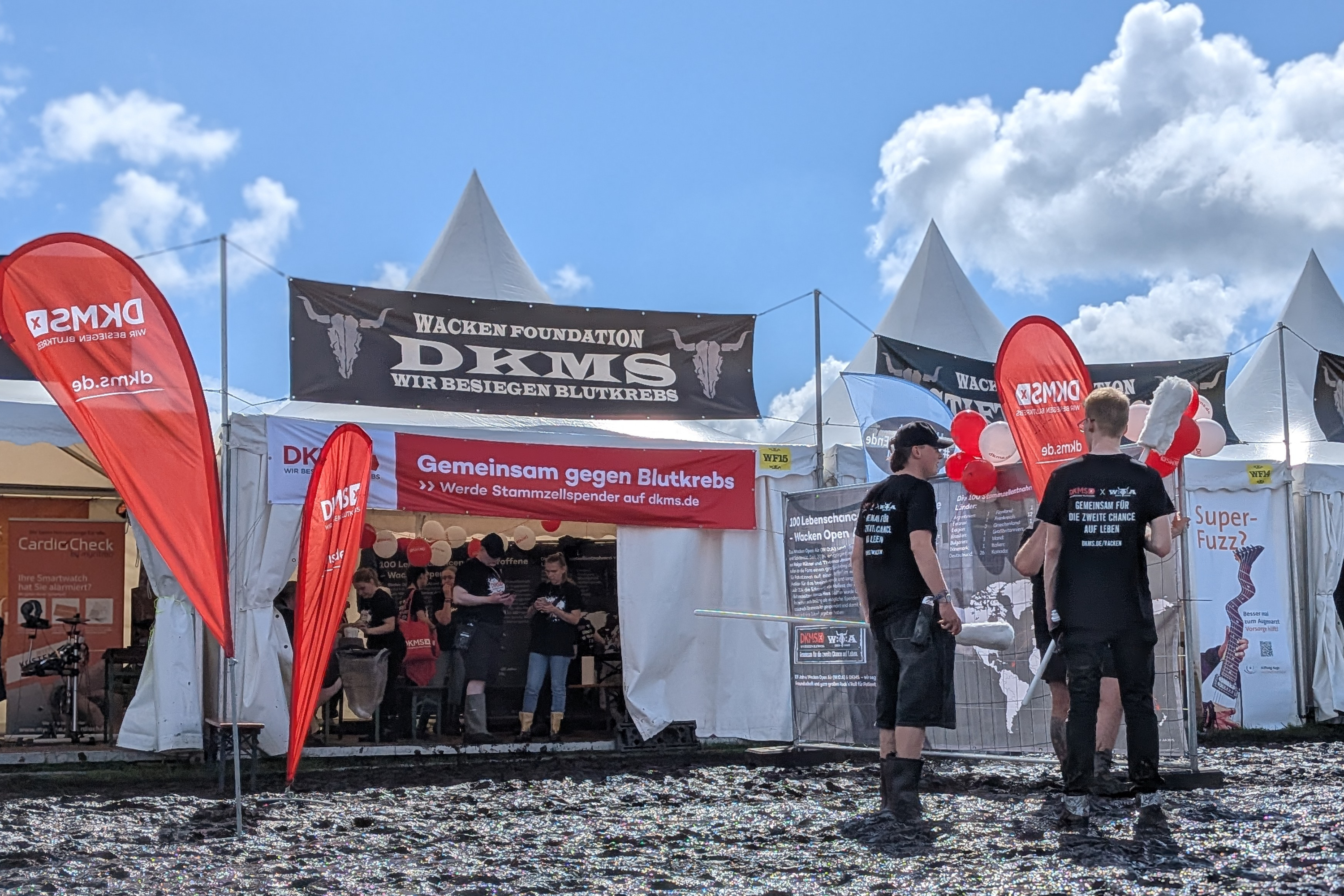 Eine Gruppe von Menschen steht vor einem Zelt