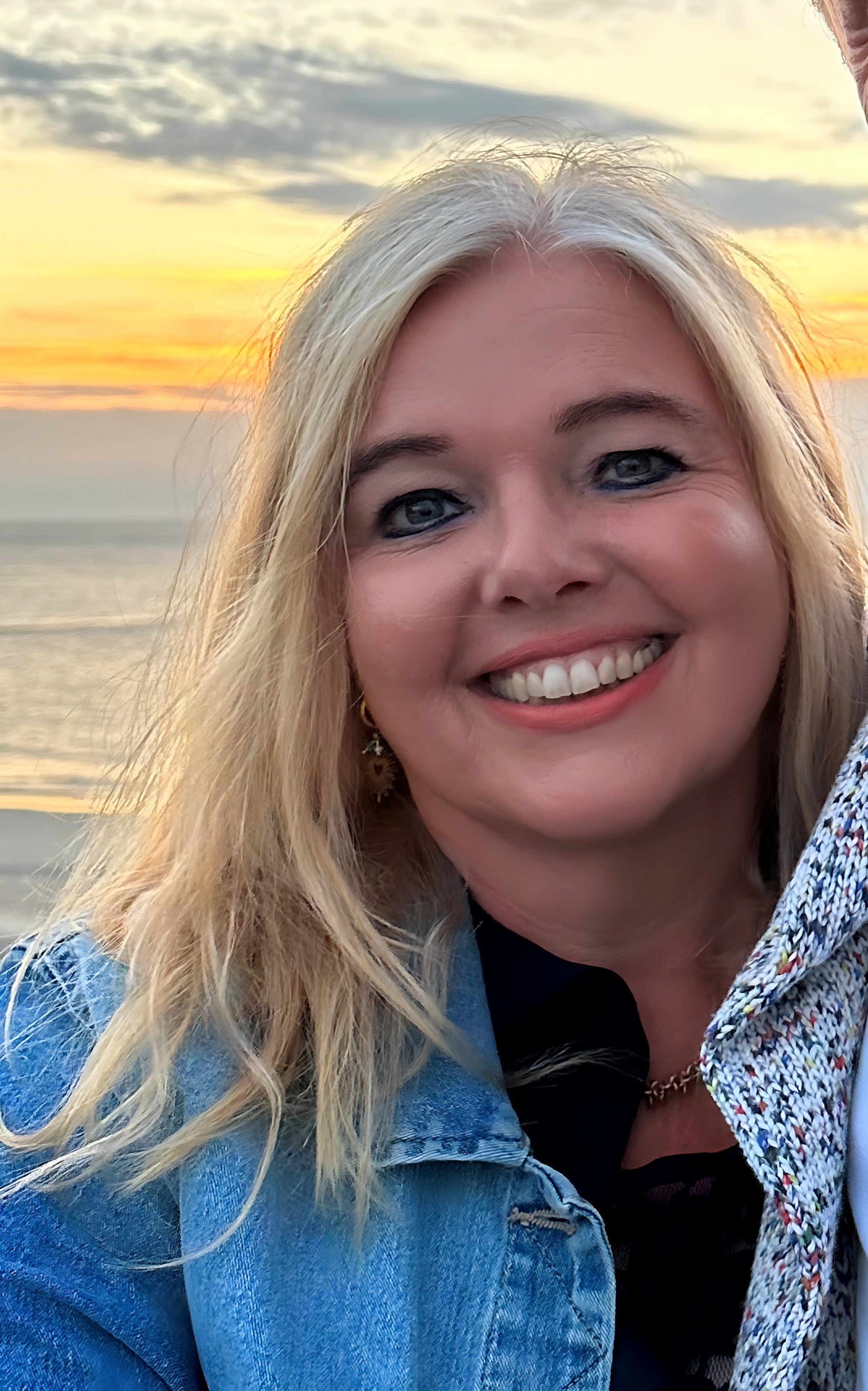 Blonde Frau lächelt in die Kamera. 