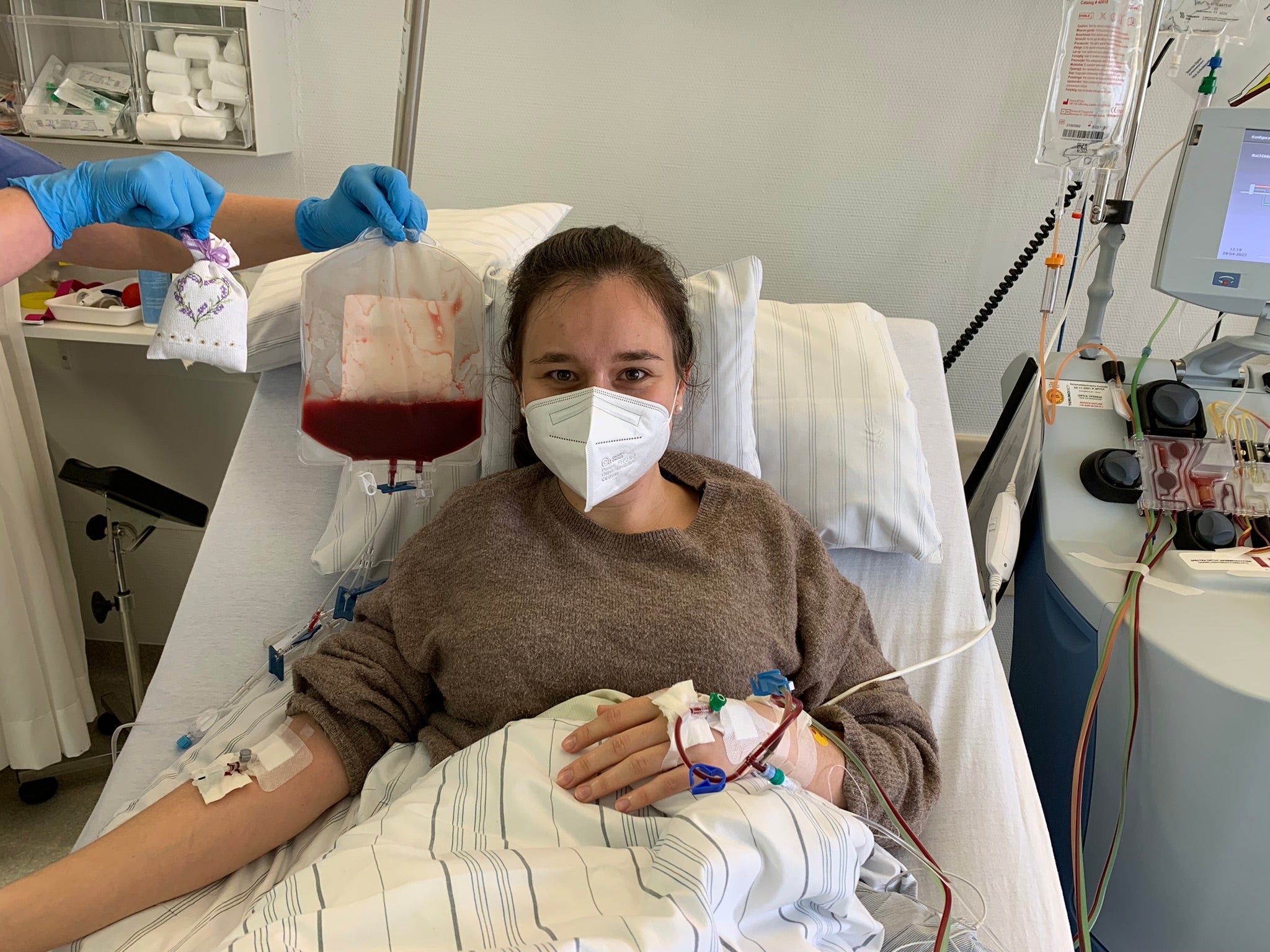 Eine Frau in einem Krankenhausbett mit einer Maske 