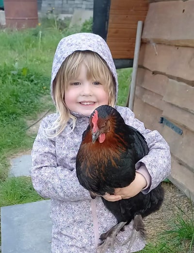 Patientin Jette mit einem Huhn auf dem Arm