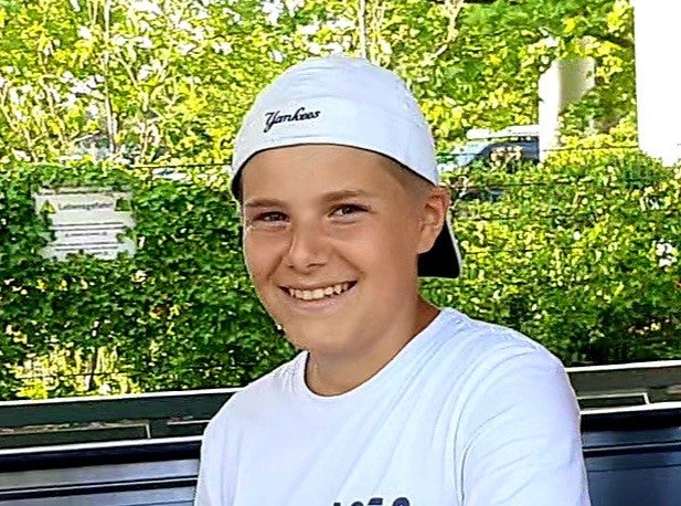 Junge mit Cap lächelt in die Kamera