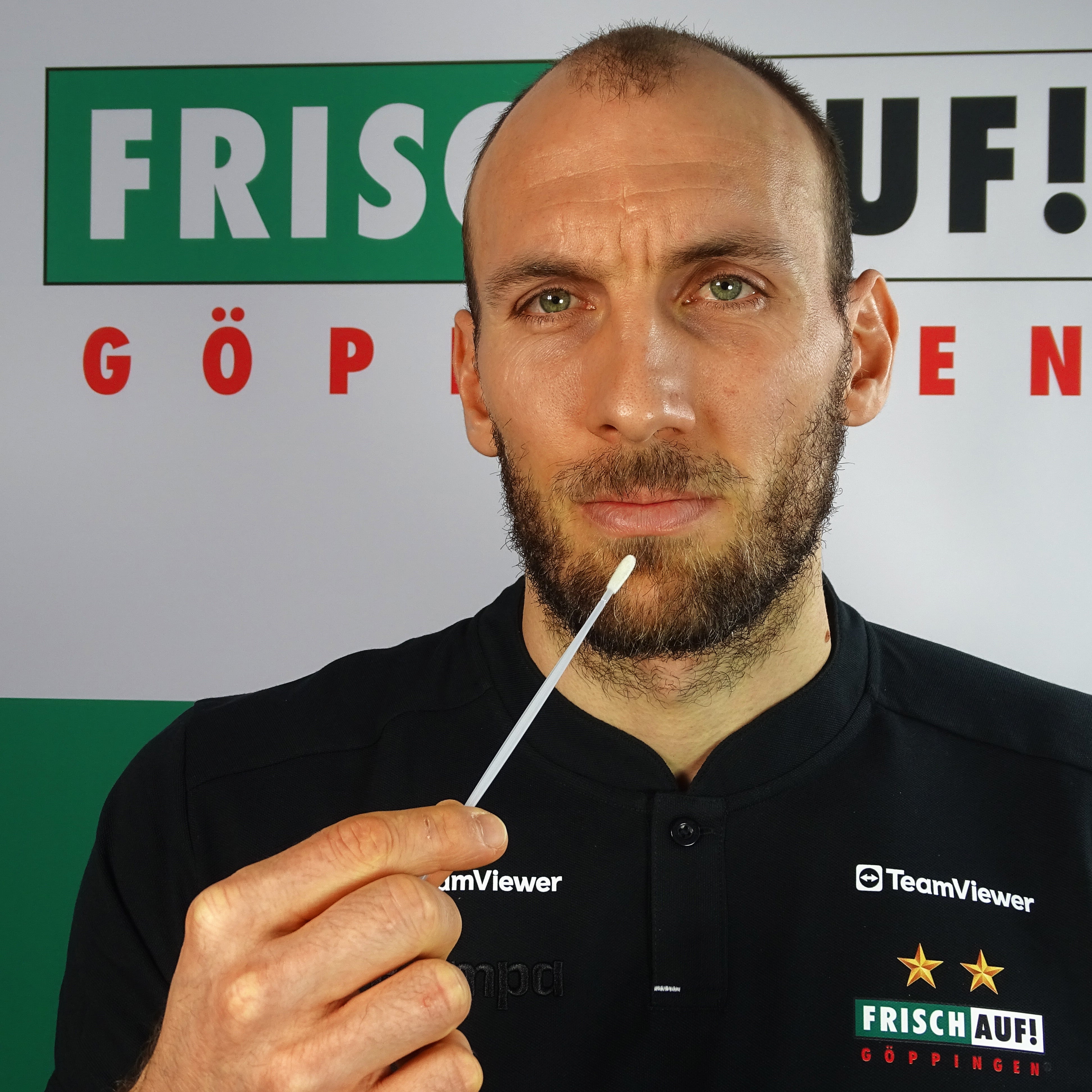 Marcel Schiller, Spieler bei FRISCH AUF! Göppingen, hält ein Wattestäbchen in der Hand.