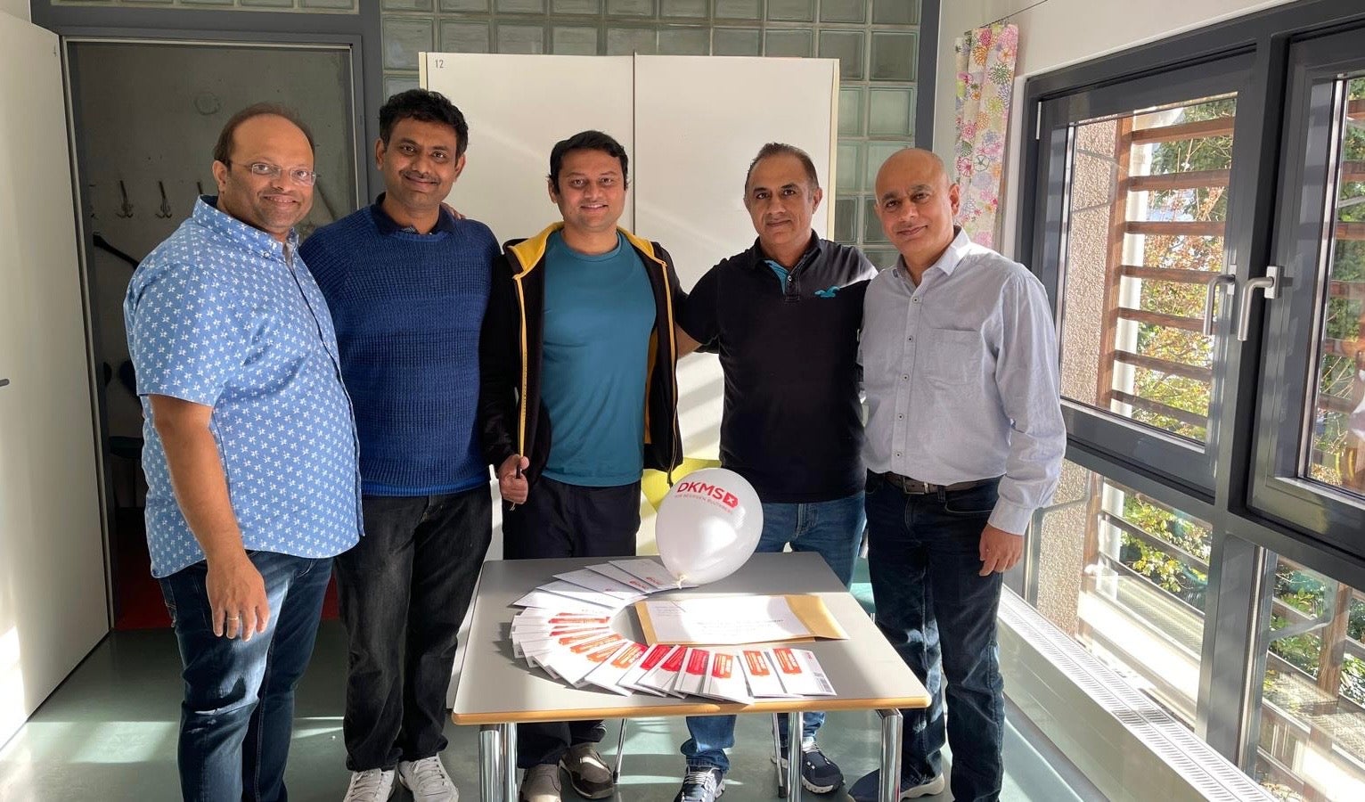 Menschen stehen um einen Tisch