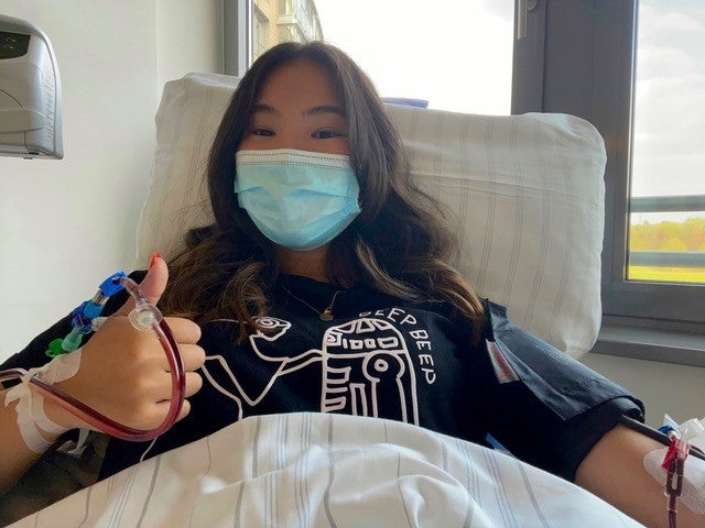 Eine Frau während ihrer Stammzellspende, sie trägt eine Maske