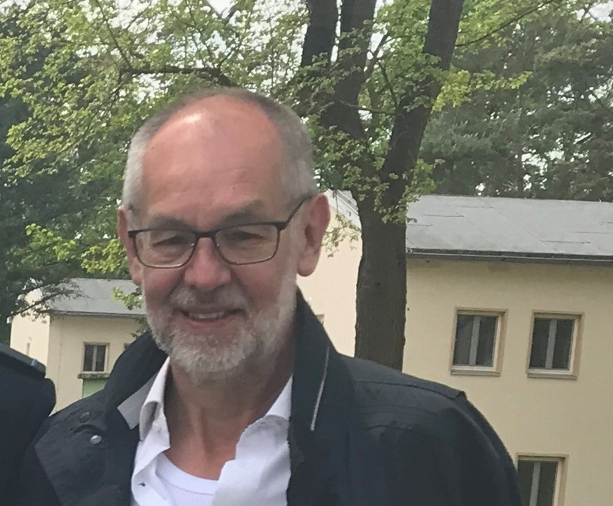 Mann mit Brille lacht in die Kamera