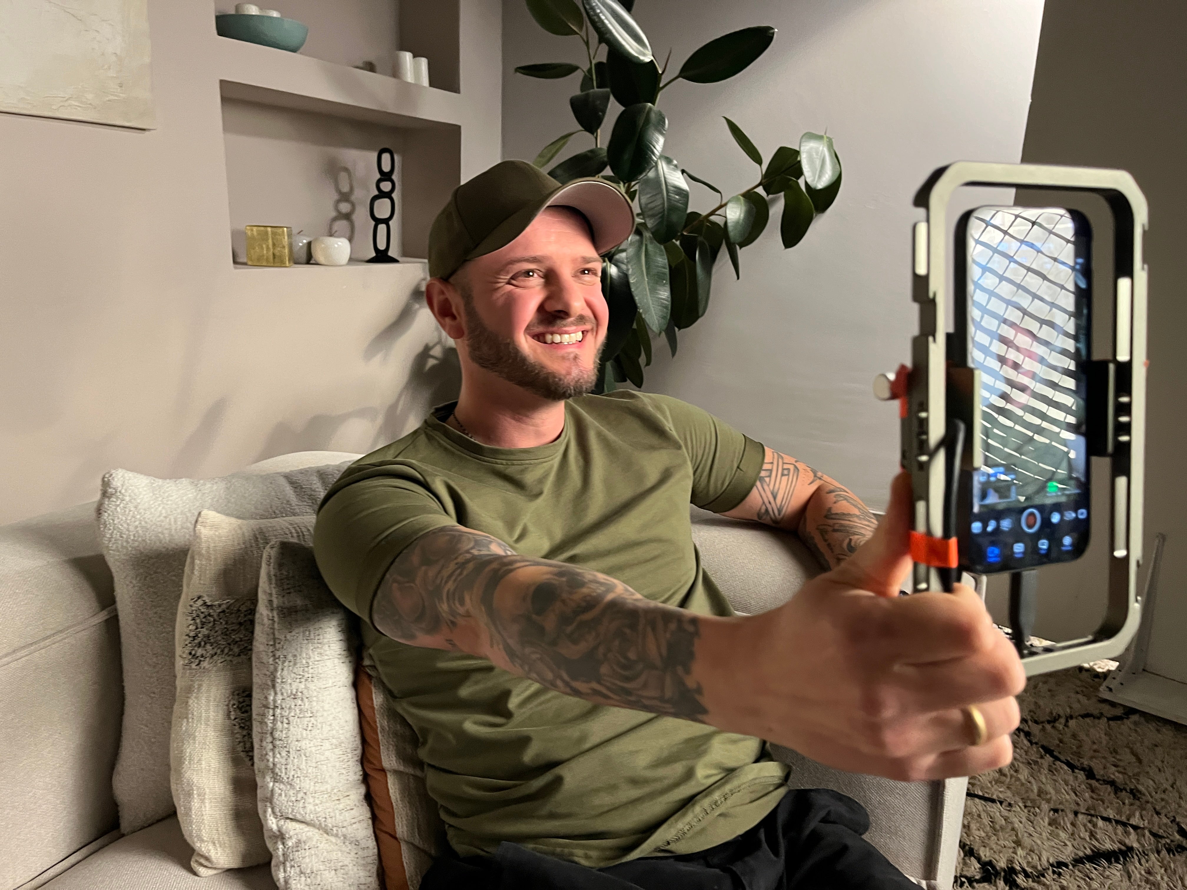 Ein Mann sitzt auf einer Couch und macht ein Selfie