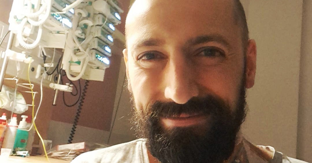 Ein Mann mit Bart lächelt