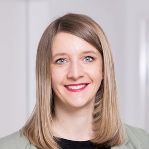 Eine Frau mit blondem Haar lächelt