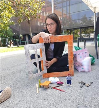 Clara Peretti, referente per il progetto QAES, mostra ai bambini del Kids Camp attraverso il gioco come arieggiare correttamente le finestre per avere un’aria più pulita (Foto: Appa Bolzano)