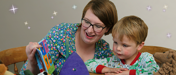 Jessica and Harry are sat at the table reading a book together 