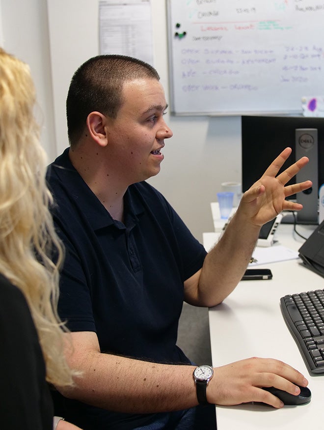 A young man and woman talking in an office