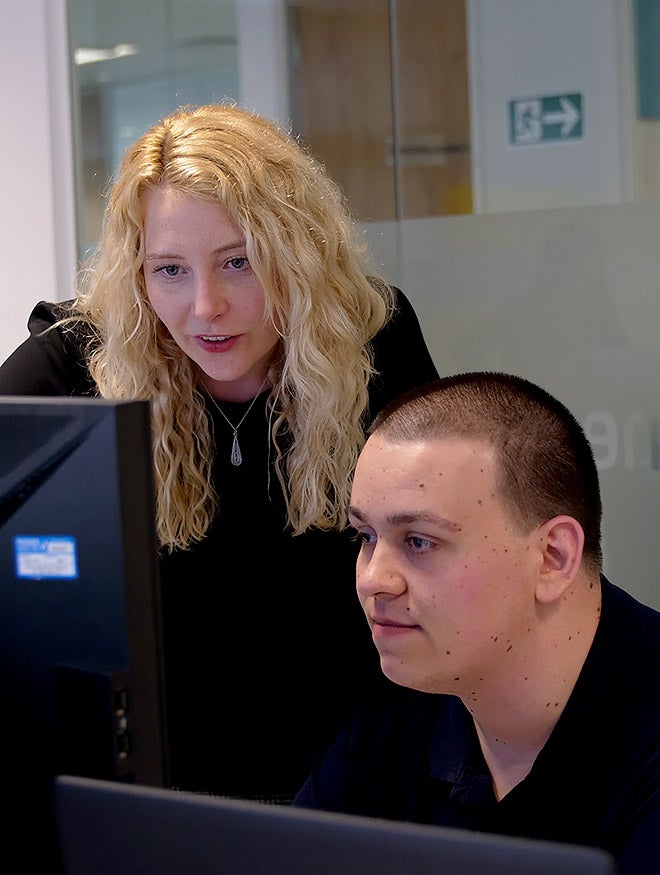 A woman and man looking at a computer screen in an office