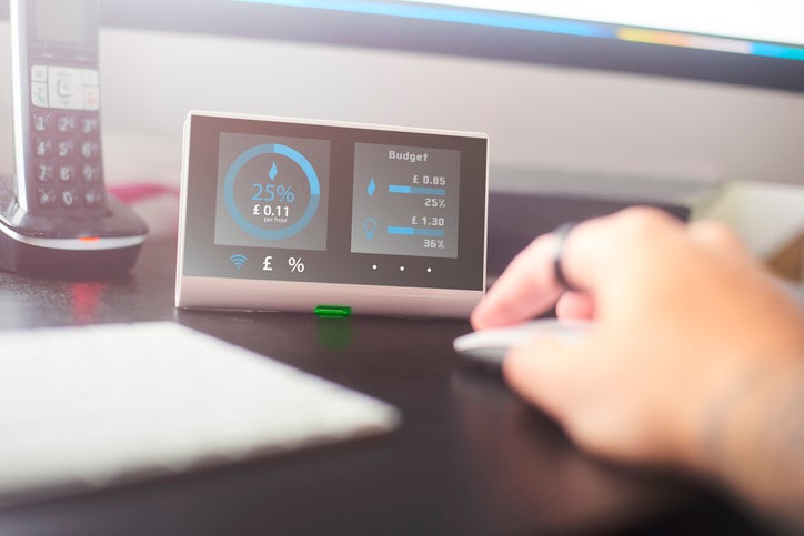 A business owner checks their business energy rates using a desktop smart meter