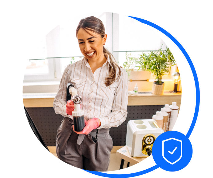 Sunbed shop owning holding spray tan gun