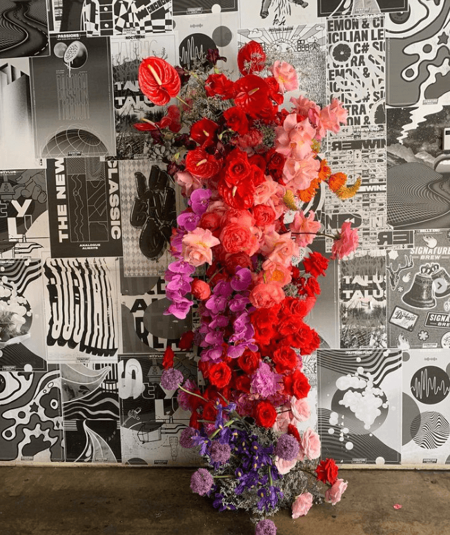 A stunning, tall floral arrangement from Filth Florist against a black and white backdrop.