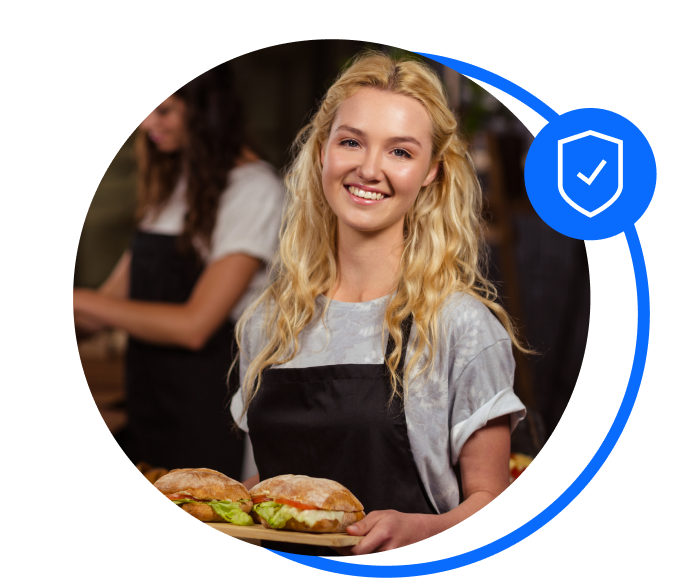 Woman holding sandwiches on a board smiling