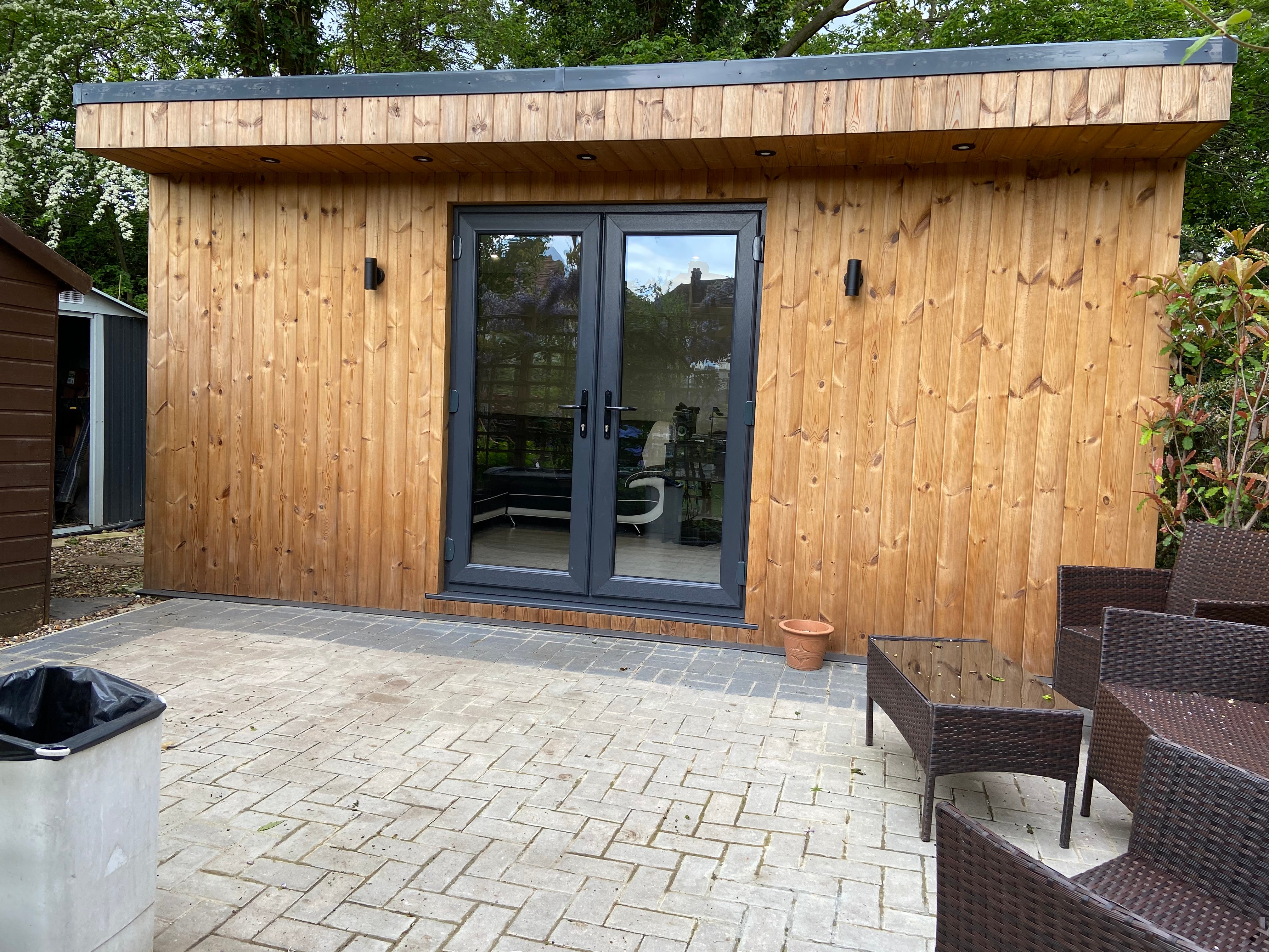 The outside of Jamie's new home salon, a wooden building with black double doors