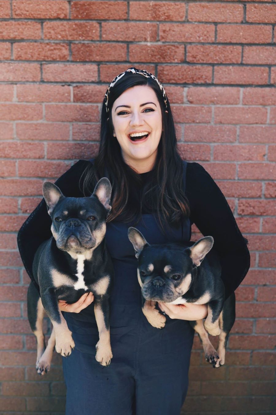 Anita poses with two French bulldogs.
