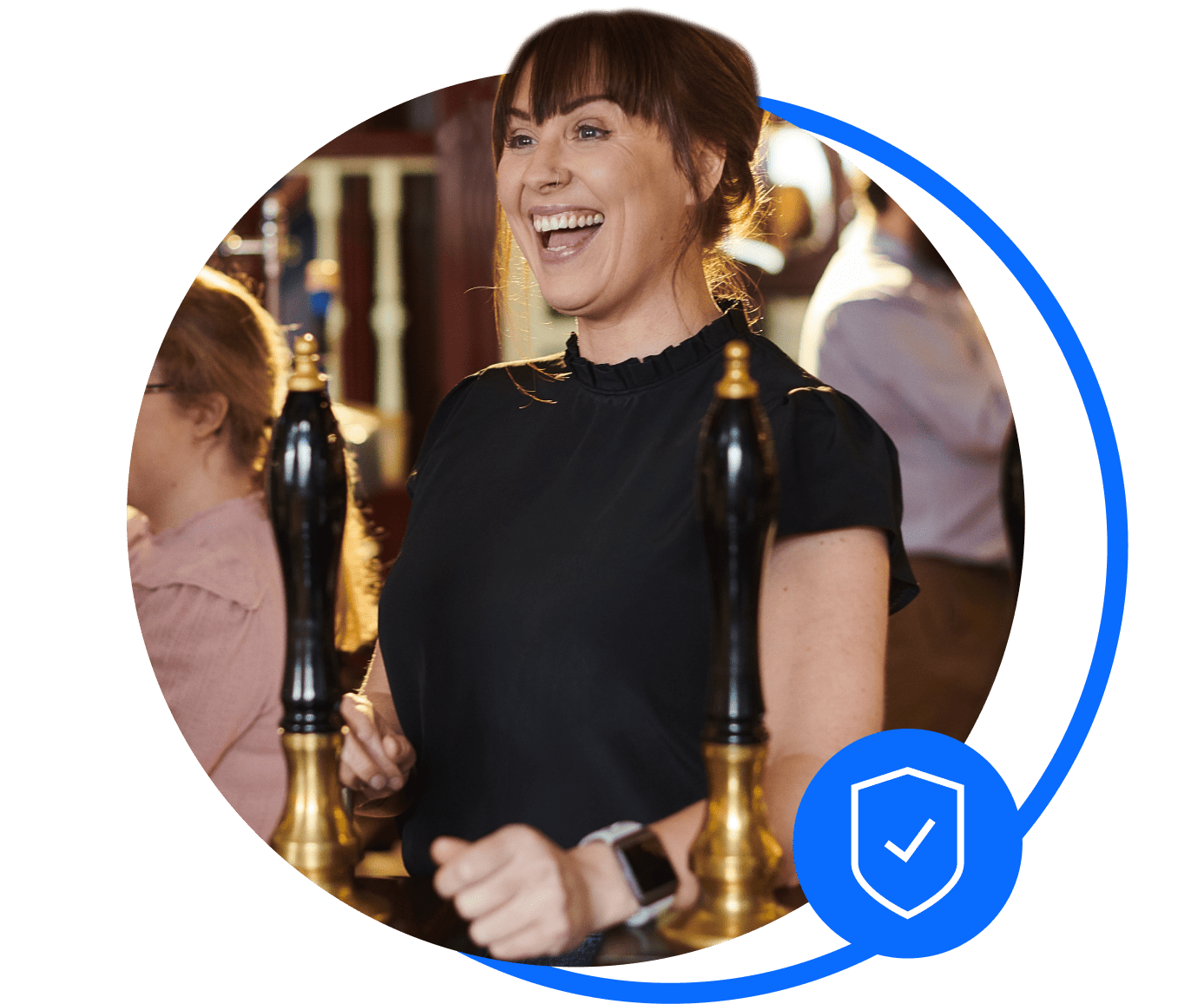 A pub landlady stands behind the bar of her pub. She's smiling at a customer after sorting her pub insurance.
