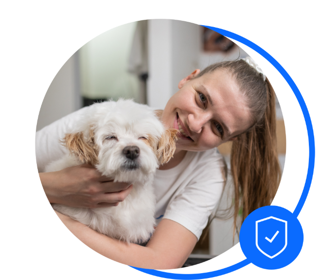 Female dog groomer holding small dog