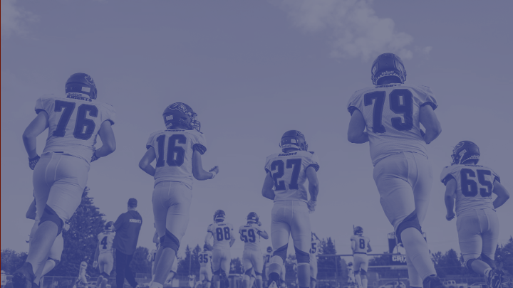 American Football players walking away from camera with a blue wash over the picture