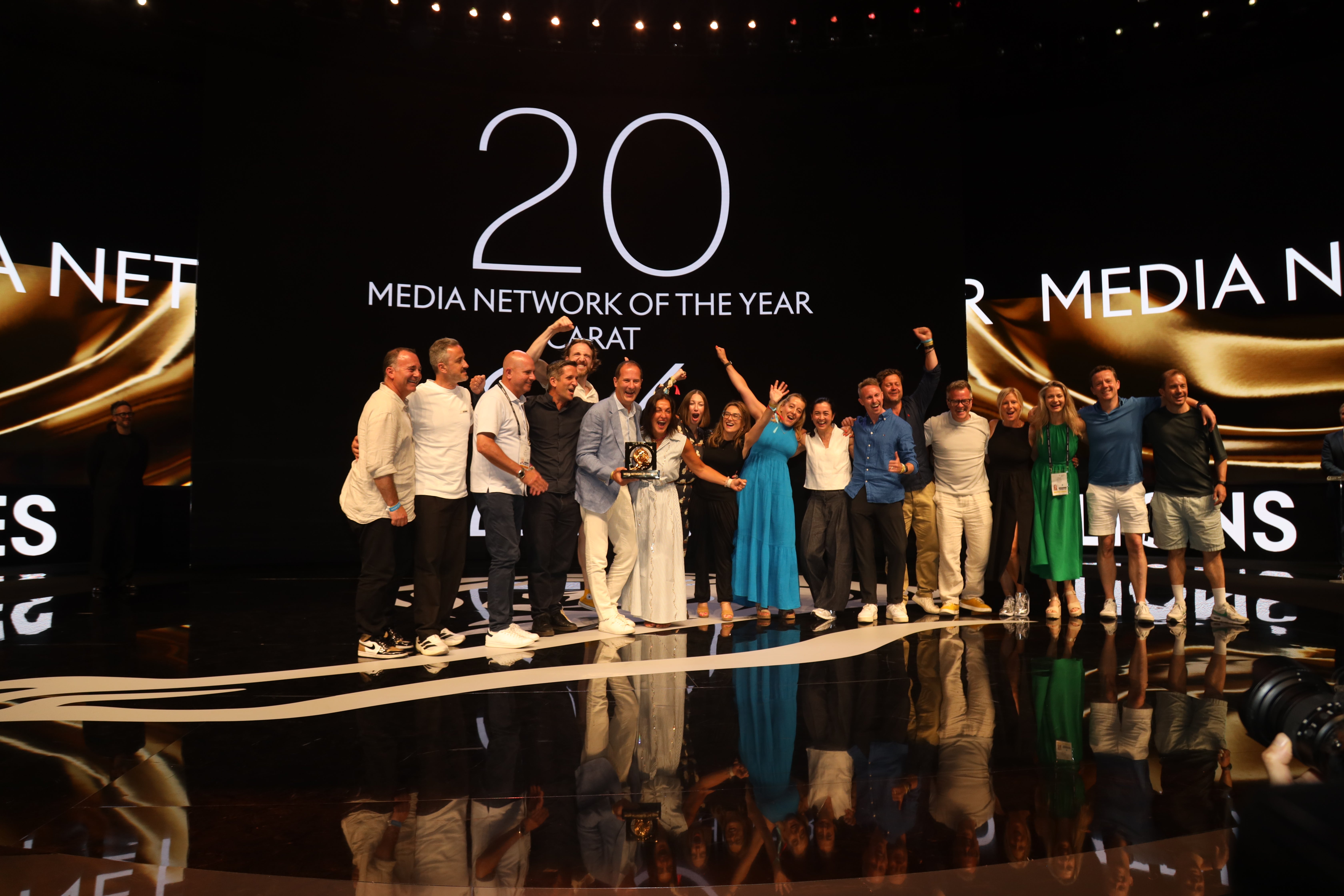 A group of people on staging celebrating winning Media Network of the year at Cannes Lions