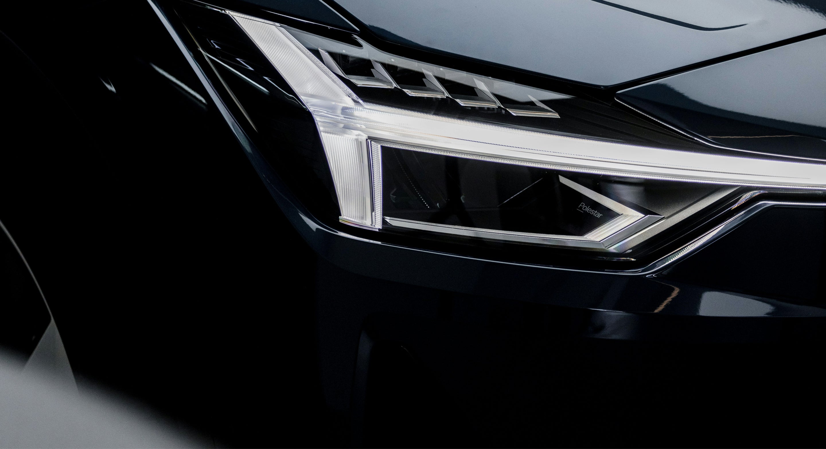 The front of a car focussing on the headlight and bumper 