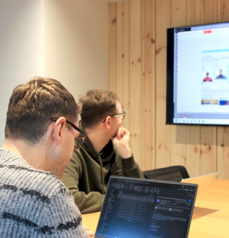 Two men looking at a screen in an office