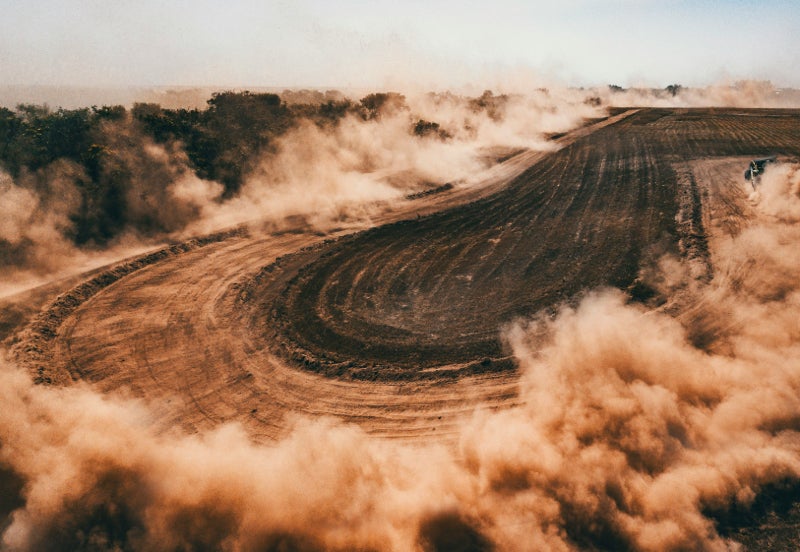 Dust cloud around a rally hairpin turn