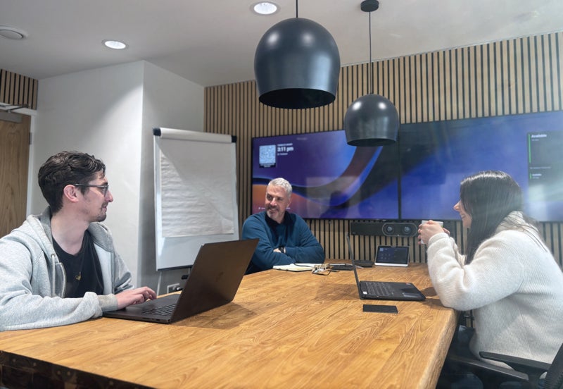 Three people in a meeting room