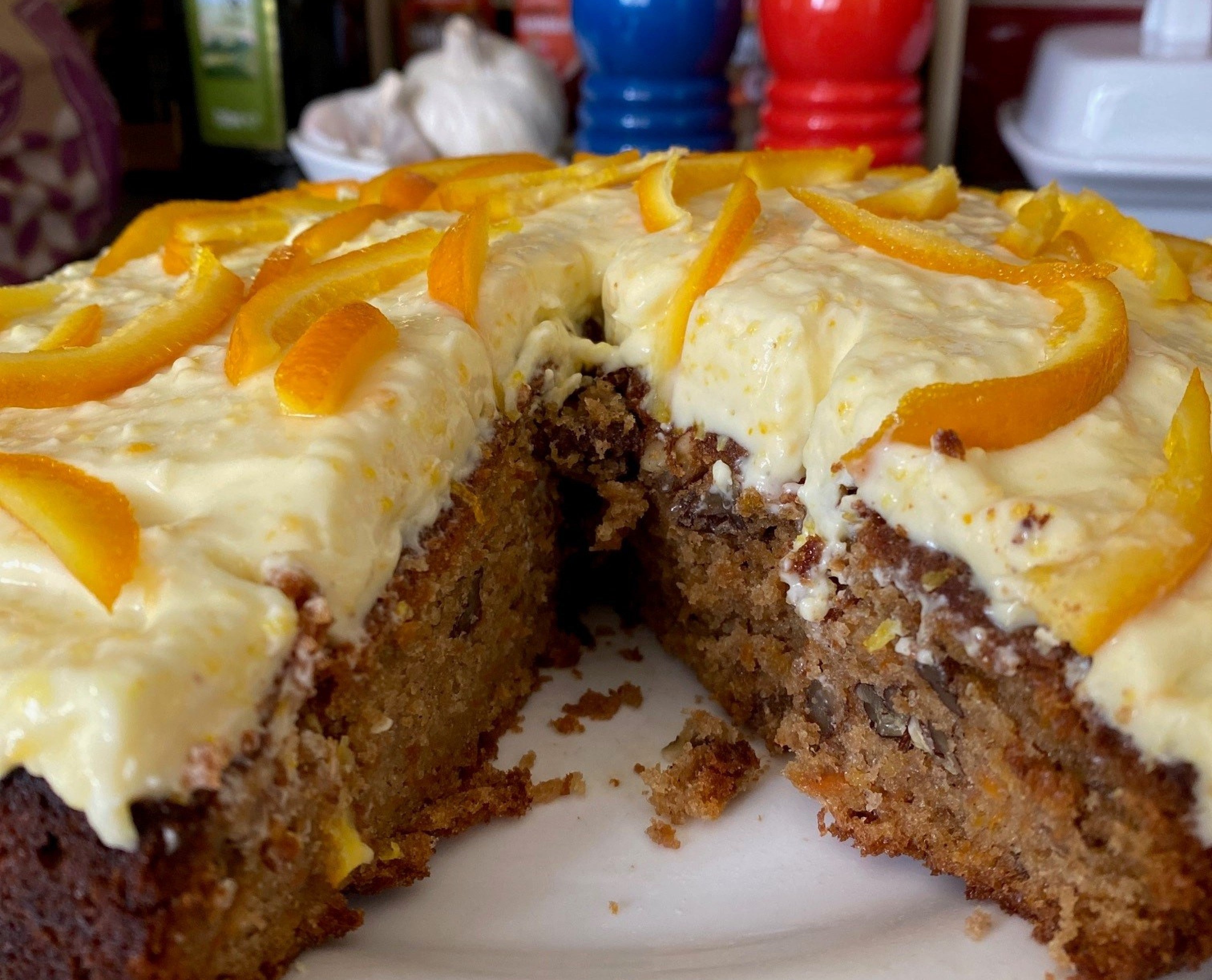 Close-up of Paul Hollywood's carrot cake made with orange buttercream and sliced of pared orange peel on top