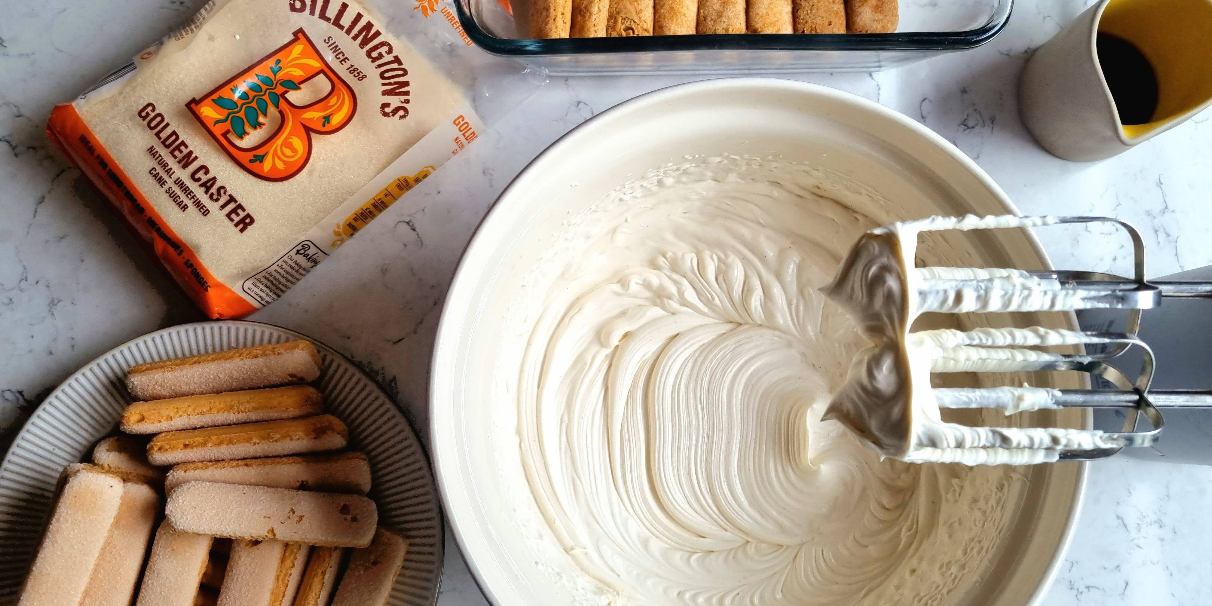 Bowl of freshly-whipped double cream next to a bag of Billington's sugar