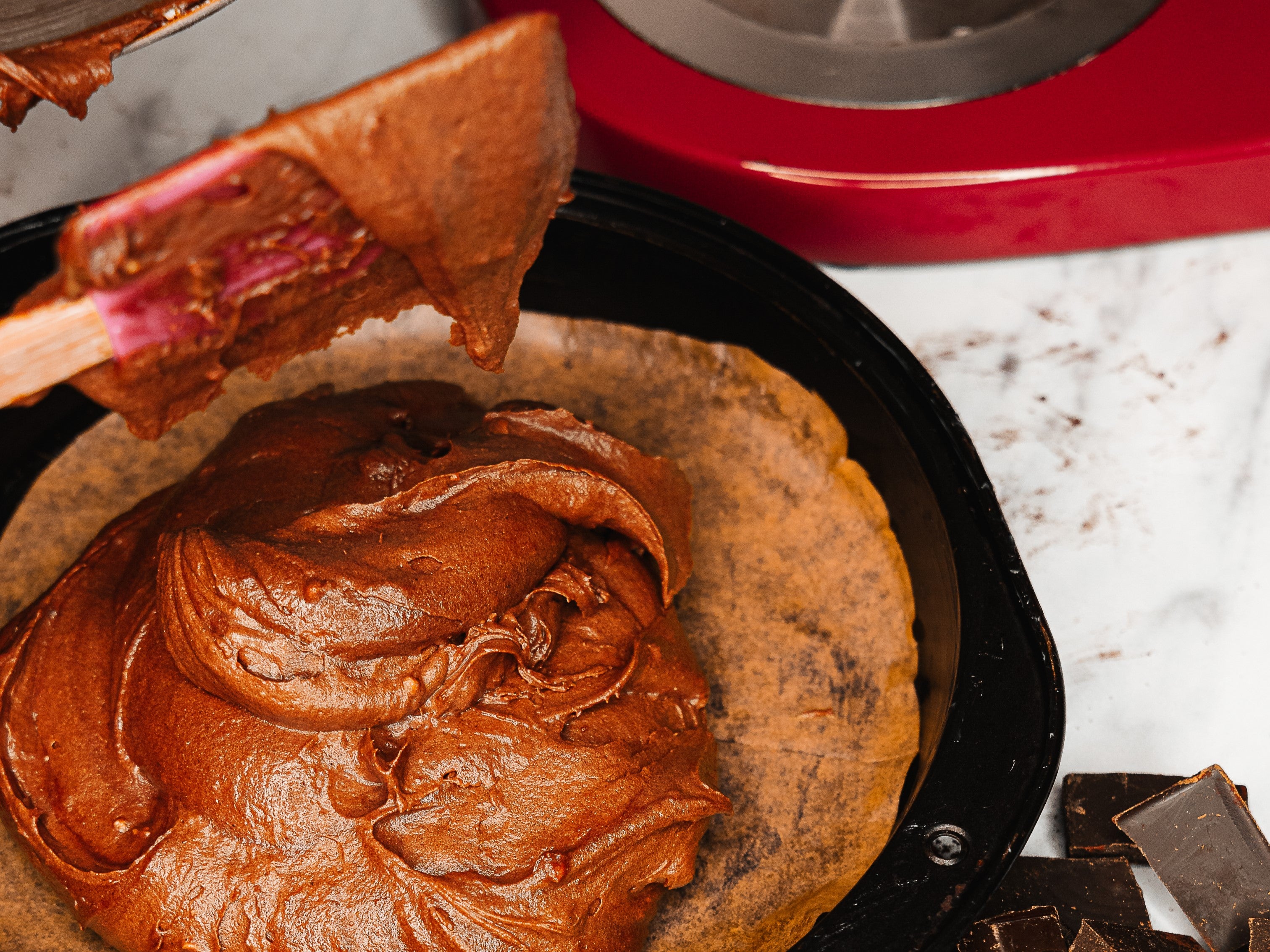 Smoothing chocolate cake batter for Nigella's chocolate cake into a baking tin lined with parchment