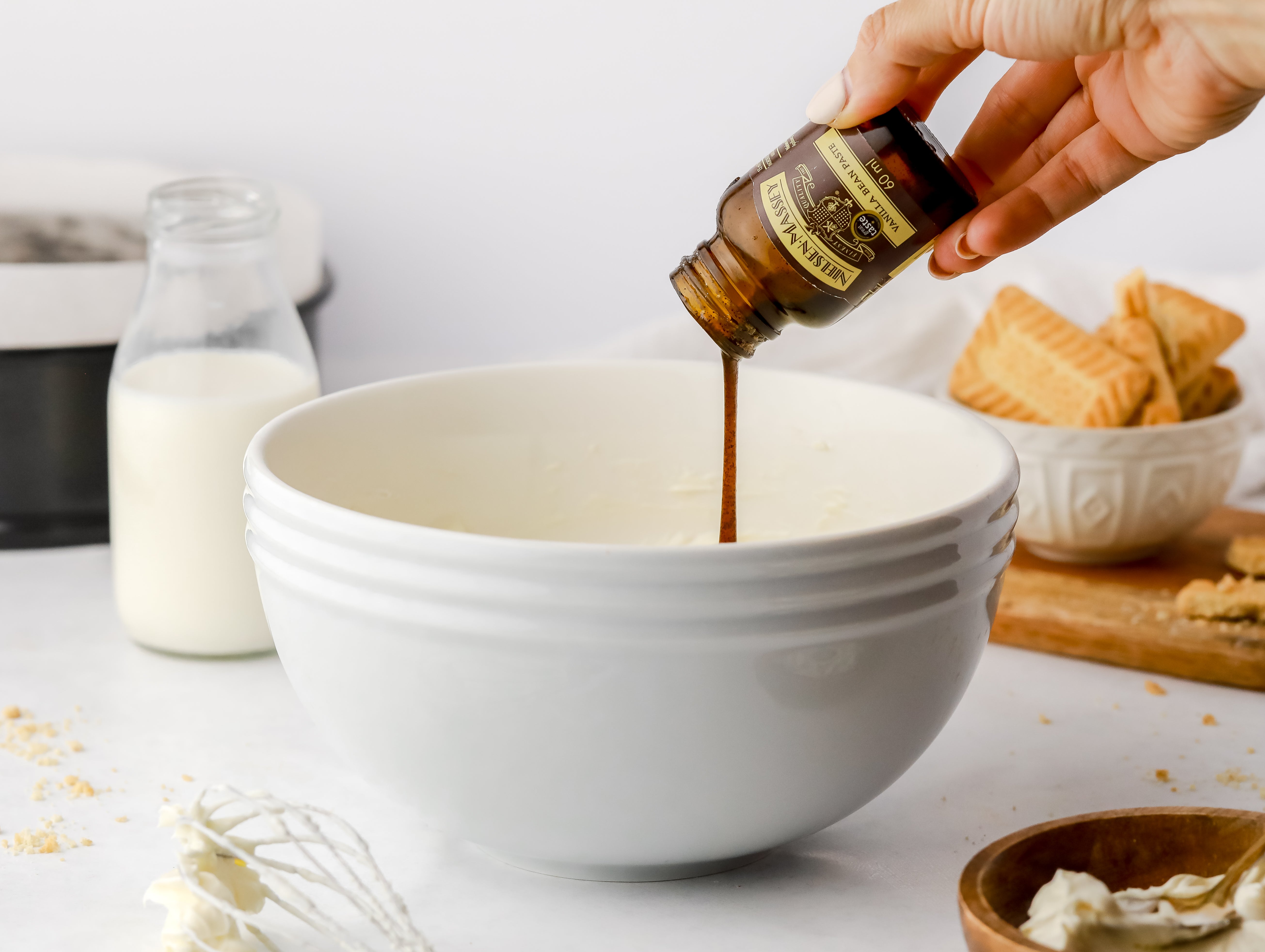 Vanilla being poured into a white ceramic bowl