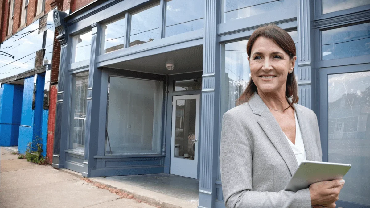 A commercial landlord stands in front of a row of vacant shops
