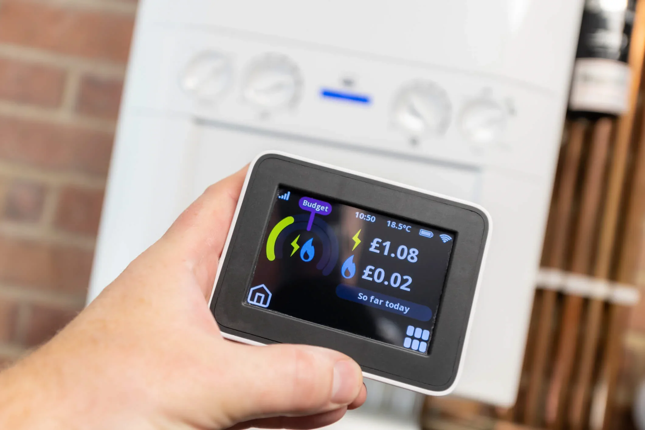 A business owner holds a smart meter to check how much gas and electricity his shop is using