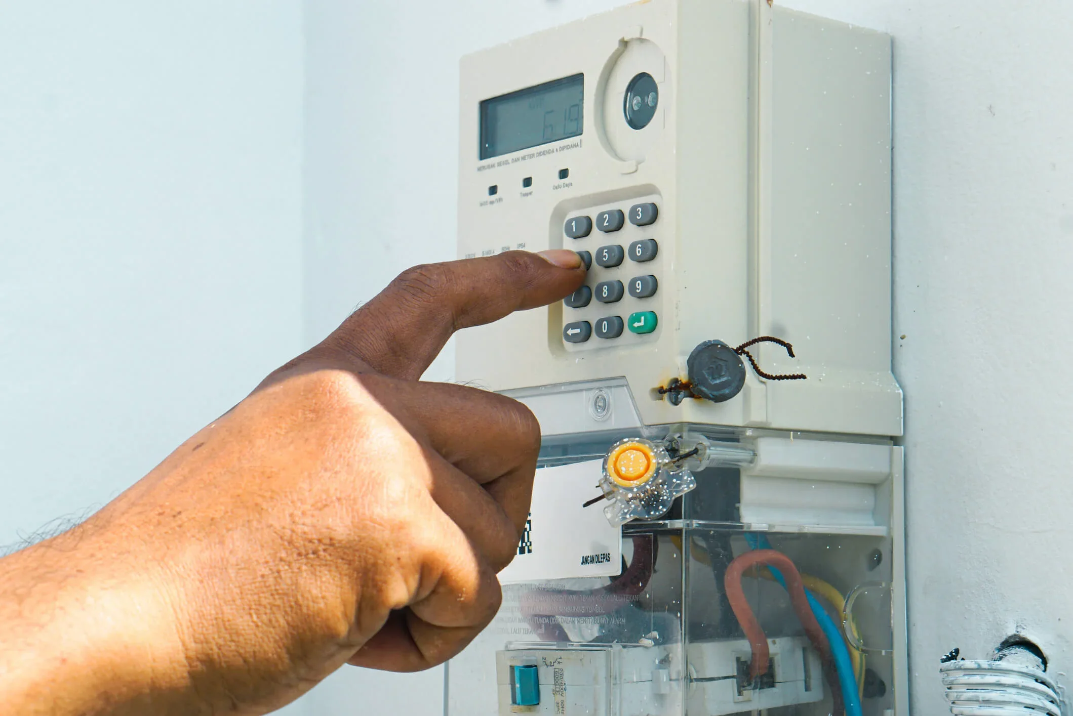 Prepaid electricity meter, hand insert code to top up electricity at a business
