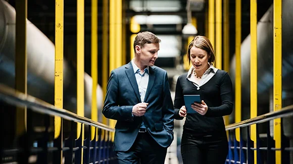 The manager of an industrial site works with an energy procurement specialist to get the best large business energy rates