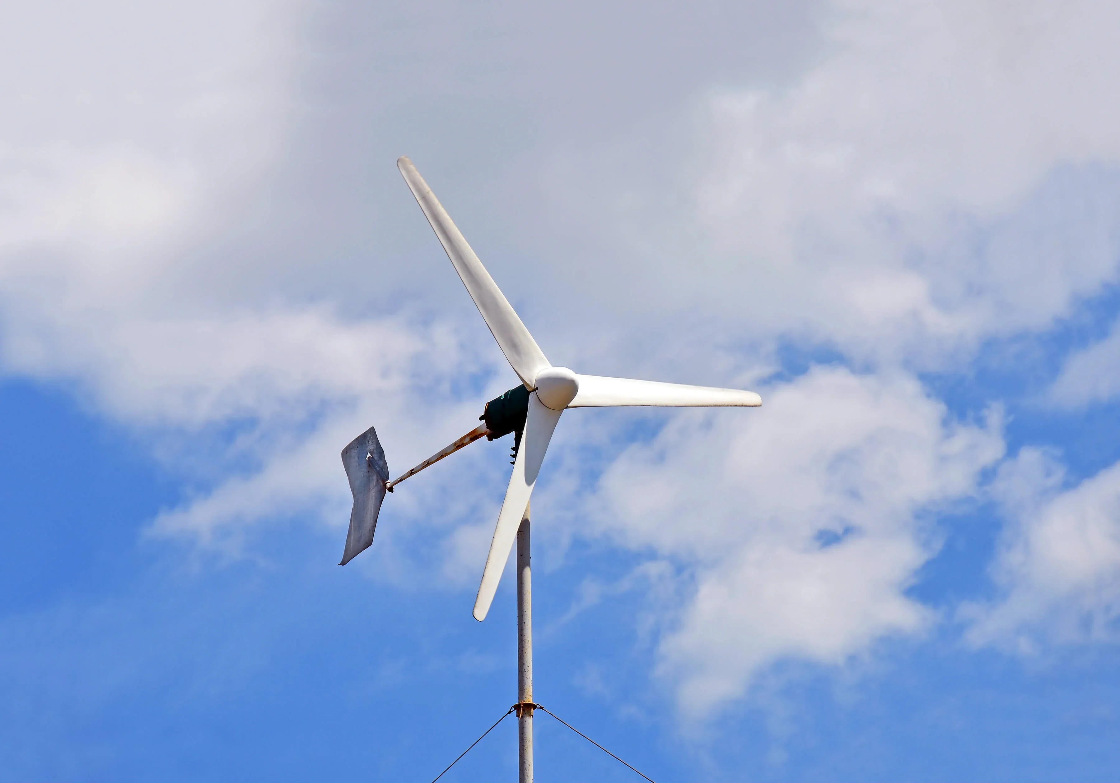 A wind power turbine used to power a small business shown on blue sky background