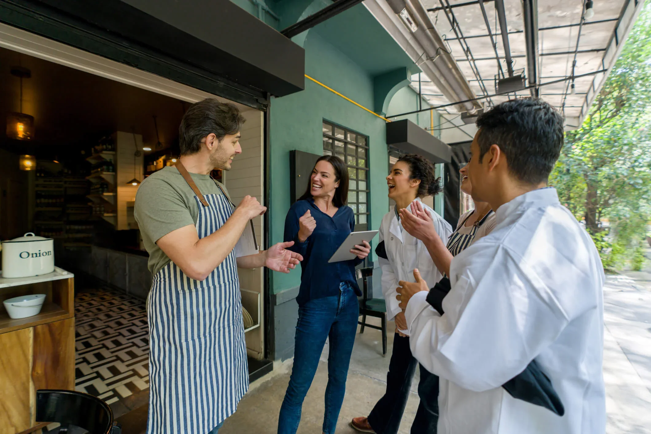 A business owner stands with three members of staff in one of her multi-site coffee shops