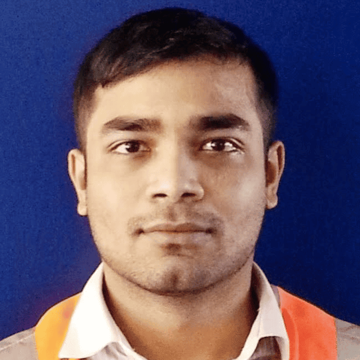 Tahmid Tonmoy, a young Asian man with a stubble and a chin dimple. He is wearing a grey shirt with a white collar and a yellow and orange scarf. He is looking at the camera.