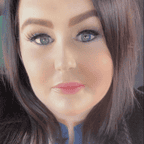 A full headshot of Vanessa Lorriman a white woman with brown hair and green eyes. She is wearing blue eyeliner, mascara, and lipgloss.