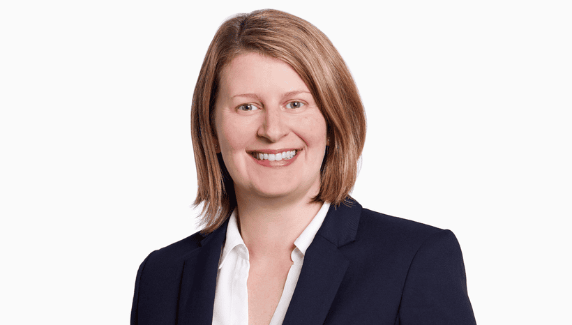 Head and shoulders shot of the solicitor Haylee Chambers, a white woman with light brown hair smiling at the camera. She is wearing a white shirt and a black suit.