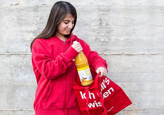 Schülerin mit Glasflasche und Stofftasche