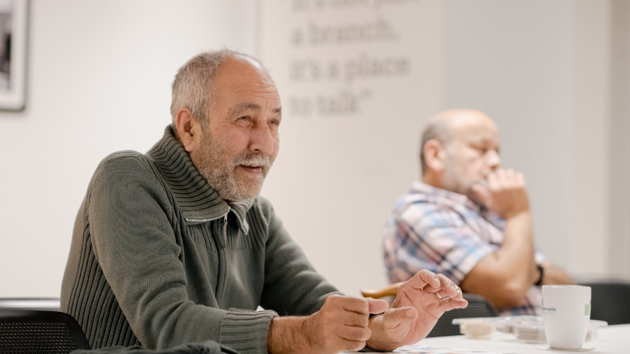 Two men sat at a table chatting.