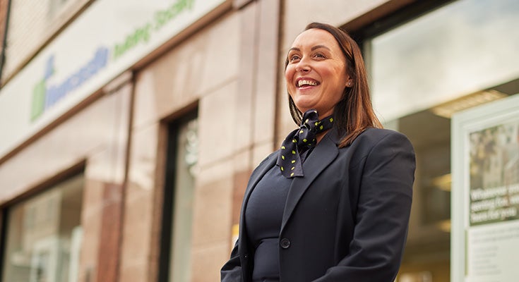 A woman smiling in front of a branch