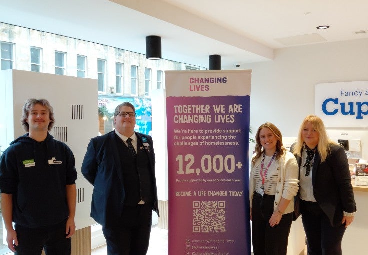 Monument branch colleagues inside the branch beside a Changing Lives banner and staff member.